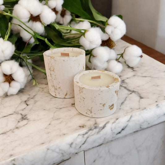 Bougie Jesmonite Alba Annalisa Candles avec des fleurs blanches en décoration sur un plan en marbre